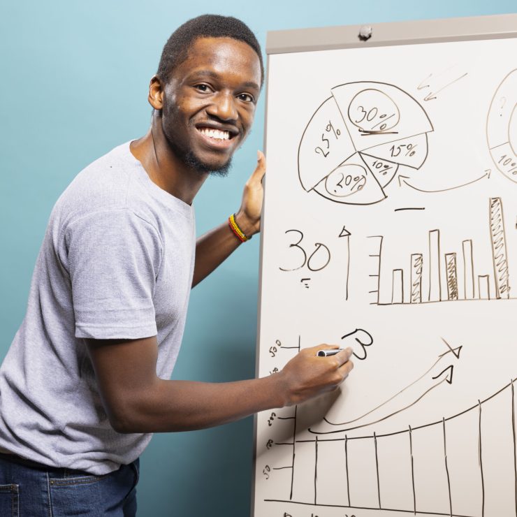 Smiling Black man explaining a chart while presenting the top 10 growth marketing services for 2025.