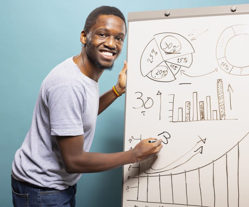 Smiling Black man explaining a chart while presenting the top 10 growth marketing services for 2025.