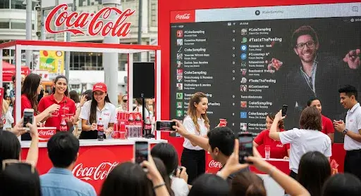 Visual of Coca-Cola sampling campaign with live audience engagement and social media amplification.